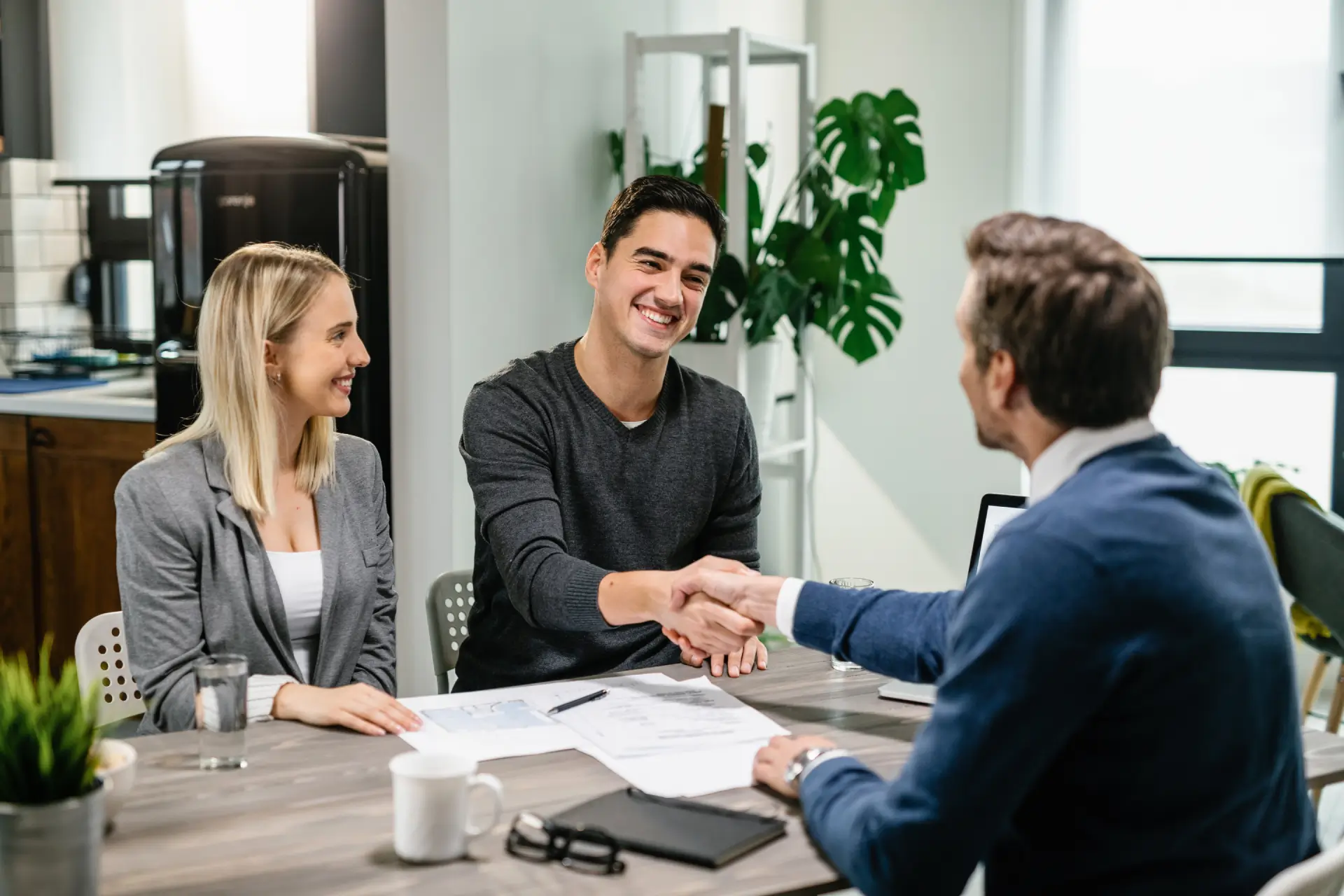 young-happy-couple-making-agreement-with-their-financial-advisor